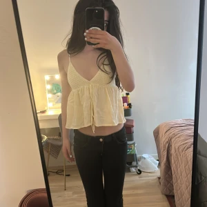 Ljusgul linnetopp med knyt - Supersöt ljusgul linnetopp med virkade detaljer upptill och v-ringning. Toppen har tunna axelband, knyt framtill och en flowy, luftig passform. Jätte bra matrial köp!!💕💕