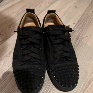 Svarta Christian Louboutin sneakers med nitar - Säljer dessa louboutins i storlek 39,5. Skorna är i mycket fint skick och låda tillkommer. Skulle säga att de passar 40-41. Skriv vid mer frågor!