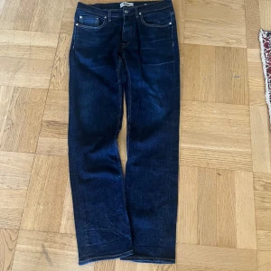 Mörkblå jeans från Acne Studios - Säljer ett par klassiska mörkblå jeans från Acne Studios i rak modell. Jeansen har fem fickor, snygga kontrastsömmar och Acne-logga på bakfickan. Tillverkade i bomull med lite stretch för extra komfort. Tar emot bud och möts gärna up!