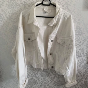 Vit jeansjacka från g perfect jeans XL - Snygg vit jeansjacka från Gina tricot i storlek XL. Klassisk modell med krage, bröstfickor med knappar och långa ärmar. Jackan har en rak passform och är tillverkad i kraftigt jeanstyg. Perfekt att slänga över en hoodie eller t-shirt.