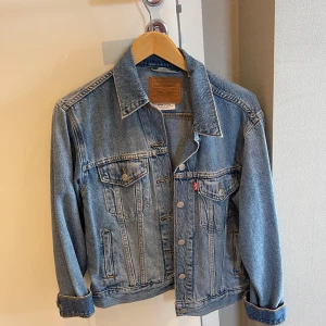 Klassisk jeansjacka från Levi's - Snygg blå jeansjacka från Levi's med klassisk passform och coola detaljer som bröstfickor med knappar och silverfärgade knappar framtill. 🫶🏼