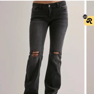 Svarta bootcut jeans med slitningar - Snygga svarta jeans med bootcut passform och slitna detaljer över knäna. Använd 2-3 gånger så i perfekt skick, sitter även väldigt bra