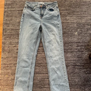 Ljusblå raka jeans från Zara - Ljusblå jeans från Zara i rak modell med hög midja. Klassisk femficksdesign och råa, fransiga benslut för en avslappnad vibe. Jeansen är tillverkade i bomull och har en snygg vintagekänsla. Perfekta till sneakers eller boots.
