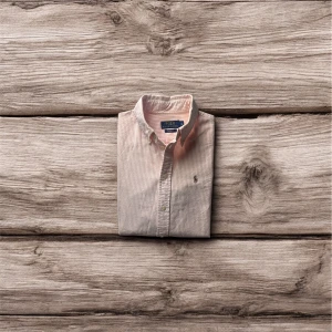 Skjorta från Ralph Lauren - Säljer en elegant och välbevarad Ralph Lauren skjorta i damstorlek S. Skjortan är tillverkad i mjuk och skön bomull och har en klassisk rosa och vit randig design. Den är i toppskick utan några synliga defekter eller tecken på användning.  Detaljer:  Material: 100 % bomull  Färg: Rosa och vit randig  Storlek: S (dam)  Märke: Ralph Lauren  Brun broderad Ralph Lauren-logga på bröstet  Perfekt för både vardag och mer uppklädda tillfällen. En tidlös och stilren skjorta som passar i vilken garderob s