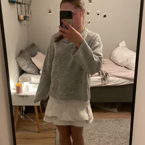 Vit jeans volangkjol - Supersöt vit jeanskjol med volangkant och klassisk jeanslook. Kjolen har knäppning och fickor fram och bak, samt en snygg volangdetalj längst ner som ger extra flärd. Kjolen är sydd själv av ett par gamla jeans från H&M och är i st S. Säljer då den inte kommer till användning💕