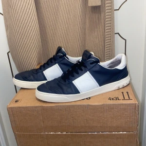 Valentino flycrews marinblå/vit  - Säljer nu mina marinblå Valentino Flycrews då jag köpt nya skor. Materialet av skon är skinn. Som ni ser på bilderna så är de några nitar som lossnat därav de låga priset, annars är de i bra skick. Storlek är i 44 men passar 44 och 43. Kan tänka mig sänka priset vid snabb affär.