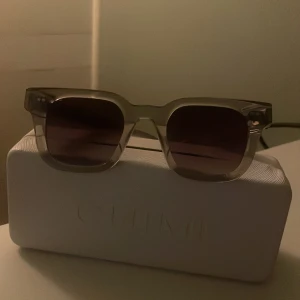  solglasögon CHIMI 04 grey - Snygga solglasögon från CHIMI med transparent grå båge och mörka linser. Rektangulär form som ger en cool vibe och passar till många stilar. Kommer med originalfodral från CHIMI.