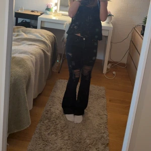 ‼️RESERVERADE‼️Svarta low waist bootcut jeans med slitningar - Säljer ett par svarta jeans med bootcut-modell och snygga slitningar över låren och knäna. De e bootcut och low waist!😍De hag ingen defekt på användning!❤️