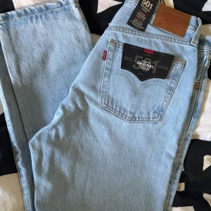 Levi's 501 Cropped ljusblå jeans - Snygga Levi's 501 Original Cropped jeans i ljusblå denim. Splitternya och helt oanvända med prislapp kvar!