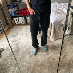 Svarta asos jeans - Säljer ett par svarta Asos jeans med klassisk straight fit. Jeansen har fem fickor, knappgylf och är tillverkade i robust bomullsdenim. Perfekta för dig som gillar en tidlös och avslappnad look.