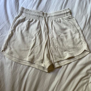 Beige mjuka shorts från H&M - Superbekväma beige shorts från H&M med elastisk midja och snörning. Tillverkade i en mjuk bomulls- och polyestermix, med fickor på sidorna.