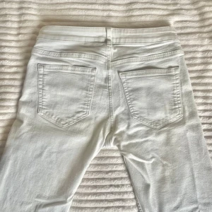 Vita bootcut jeans från H&M - Jättefina vita low wasted jeans från HM. Byxorna är tyvärr för korta för mig men är fortfarande otroligt fina! (Är 1,73 för referens) jeansen har jätte små fläckar som visas på bild, men är inget som förstör helheten av dessa fräscha byxor, passa på!💗 