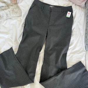 Y2K office siren 2000s striped gray pants bootcut  - Snygga bootcut byxor med tunna ränder i vitt. Passar bra till jobb eller helt enkelt en stroll på stan!
