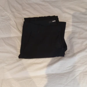 Svarta kostymbyxor från BikBok - Svarta kostymbyxor från BikBok i storlek 38. Byxorna har en klassisk rak passform med hällor för bälte och diskreta fickor. Perfekta för en clean och stilren look. Materialet känns mjukt och följsamt. Pris kan diskuteras 