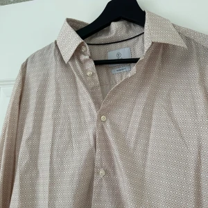 Beige mönstrad skjorta från Bläck - Herrskjorta från Bläck med  mönster i beige.  Använd en gång så nyskick. 