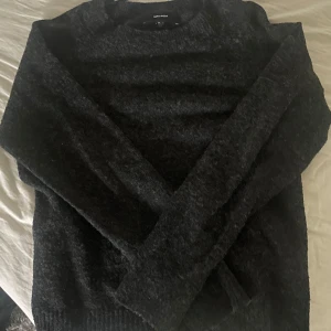 Mörkgrå/svart stickad tröja från Vero Moda - Mysig mörkgrå/svart stickad tröja från Vero Moda. Passformen är normal. 