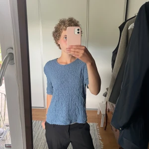 Söt blå topp - Säljer en blå topp från Vila med rund halsringning och strukturerat tyg. Superbra skick och den är normal i storleken.