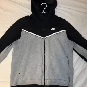 Svart/grå Nike Tech Fleece - Säljer en Nike Tech i färgen svart/grå. Finns täcken på användning. Nypris 1300kr. Kvitto finns!