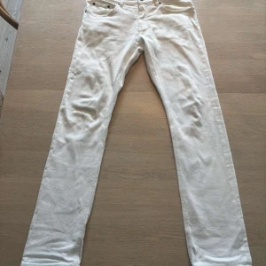 Vita jeans från Bläck, storlek 46 - Snygga vita jeans från Bläck i storlek 46. Modellen har klassisk femficksdesign, raka ben och normal passform. Jeansen är tillverkade i bomull och har en stilren look som passar perfekt till sneakers eller boots.