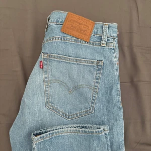 Levi's 511 ljusblå jeans W33 L34 - Säljer ett par Levi's 511 jeans i ljusblå tvätt som är aldrig använda. Klassisk femficksmodell med smal passform och raka ben. Jeansen har snygga slitningar och den ikoniska läderpatchen bak i midjan. Perfekta för en avslappnad och trendig look.