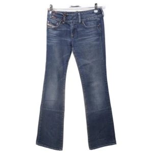 Blå bootcut jeans från Diesel Cherone - Snygga blå jeans från Diesel, modell Cherone, med klassisk bootcut och femficksdesign. Jeansen har en mörk tvätt med lätt slitning och är tillverkade i mjukt denimtyg. Perfekta för dig som gillar en tidlös och avslappnad look.