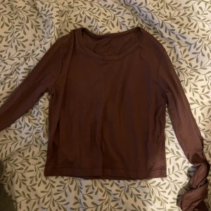 Brun långärmad tröja i bomull - En basic brun långärmad tröja med rund halsringning. Tillverkad i mjuk bomull, perfekt för lager-på-lager eller som enkel topp. Stilren och enkel design som funkar till många outfits.