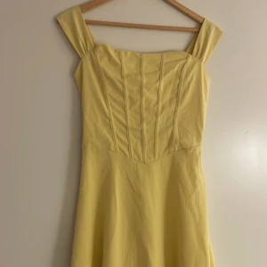Ljusgul långklänning från SHEIN XS - Superfin ljusgul långklänning från SHEIN i storlek XS. Klänningen har breda axelband, markerad midja och snörning i ryggen för extra snygg passform. Tillverkad i ett lätt och mjukt material som ger ett flowy intryck. Perfekt för sommarens alla tillfällen!