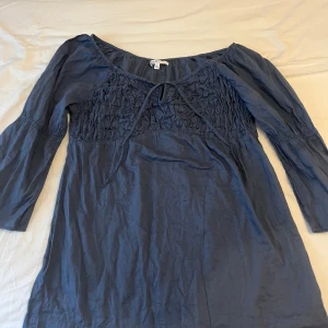 Marinblå blus med detaljer - Superfin och luftig marinblå blus med detaljer över bysten och knyt framtill. Köpt från Kappahl och kommer inte mer till användning. Kontakta gärna innan köp!