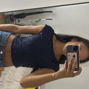 Mörkblå glittrig topp från SHEIN - Säljer en mörkblå croppad topp från SHEIN med glittriga paljetter. Toppen har korta ärmar och öppen rygg, perfekt för att sticka ut. Sitter tight och har en snygg, modern look.