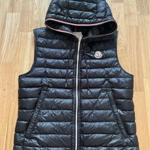 Moncler Gilet väst - Säljer en Moncler Gilet väst, en stor favorit bland mina västar o kunder. Skick - 9/10. Jättefräsch väst o har aldrig använts. Äkta!! 