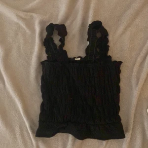 Linne - Ett svart linne med volanger på