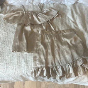 Beige omlott blus med volang från Lindex - Supersöt sätt från Lindex! En fin topp med volang och till det en kjol. Lite ”snören” sticker ut men har använts få gånger!