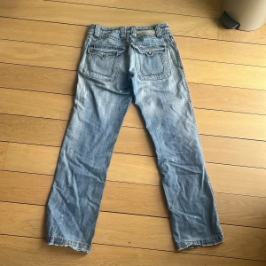 Sorbino ljusblå jeans med stora fickor - Ljusblå jeans från Sorbino med raka ben, stora fickor både fram och bak samt slitna detaljer och röd kontrastsöm. Jeansen har en klassisk femficksdesign och är tillverkade i denim med en cool, avslappnad vibe.