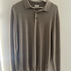 Merinoull tröja John Henric - Snygg beige pikétröja från John Henric i mjuk ull. Klassisk krage, knäppning med två knappar och långa ärmar. Perfekt för dig som gillar stilrena och tidlösa plagg med en chill vibe. 100% merinoull