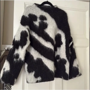 Zebramönstrad alpacka stickad tröja Stockh LM - Säljer en oversized stickad tröja från Stockh LM Studio i storlek XS. Tröjan har ett svartvitt zebramönster och är fluffig med lång ärm. Perfekt statement-plagg för dig som gillar att sticka ut med coola mönster och mjuka material.