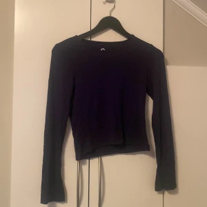 Mörkblå långärmad tröja C 158/164 - Enkel och stilren mörkblå långärmad tröja från C i storlek 158/164. Tröjan har en rak passform och är tillverkad i ett mjukt, stretchigt material som känns skönt mot huden. Perfekt att matcha med jeans eller kjol för en clean look.