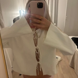 Vit kofta med snörning - Superfin och söt vit kofta/tröja med knytning/rosetter och vida ärmar 🙌🏽🤍 Köpt i vintras och använd några gånger men i väldigt fint skick