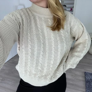 Beige stickad tröja Pernilla Wahlgren - Säljer en beige stickad tröja från Pernilla Wahlgren Design. Tröjan har kabelstickat mönster, hög ribbad krage och långa ärmar. Perfekt för dig som gillar en mysig och stilren look med lite loose fit. Önskar du veta exakta mått? Tveka inte att höra av dig!