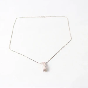 Silverhalsband med minimalistiskt hänge - Stilrent halsband i äkta 925 silver med ett modernt, avlångt hänge i matt finish. Hänget har en diskret sned detalj och kedjan är tunn och fyrkantig. Perfekt för dig som gillar enkel och tidlös design.