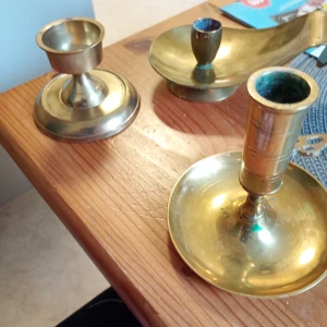 Mässing ljusstakar - Bilderna visar tre mässingsljusstakar i klassisk stil, perfekta för att skapa mysig stämning i rummet. Passar både till vintage-inspirerade inredningar och för dig som gillar unika detaljer. Snygga att ha på skrivbordet, fönsterbrädan eller som dekoration vid fest.