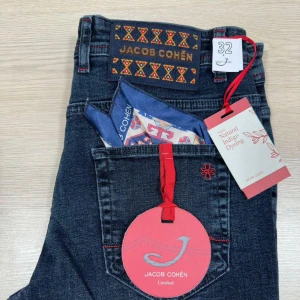 Helt nya Jacob Cohën Limited jeans, mörkblå - Helt nya storlek 30 Exklusiva mörkblå jeans från Jacob Cohën Limited med snygga röda detaljer och broderad logga på bakfickan. Tillverkade i jeansmaterial med naturlig indigo-förgning