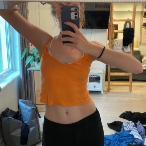 Orange ribbad linnetopp Brandy Melville - Säljer en orange ribbad linnetopp från Brandy Melville. Toppen är croppad med smala axelband och v-ringad hals. 