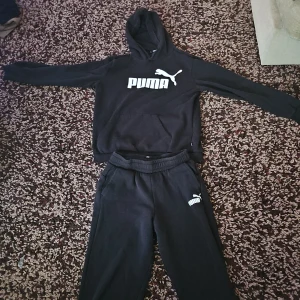Svart hoodie och byxa från Puma med logga - Svart hoodie och svart byxa från Puma med bra design. Bra fit som passar sport och allt annat. Mycket bra skick och har inga hål eller märken på tröjan och byxan.