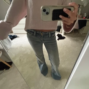 Bootcut jeans från weekday - Säljer ett par ljusblå low bootcut jeans från Weekday. Stl 26/32 men de är uppsydda (på bilderna ser ni hur de är på mig som är 166 cm), aldrig använda endast testade och uppsydda så bra skick. Enda defekten syns på sista bilden då en logga är bortdragen.