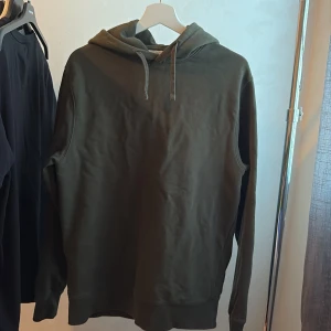 Hoodie these glory days - Snygg olivgrön hoodie med huva och snörning. Tröjan har en klassisk passform och långa ärmar, perfekt för en chill och avslappnad stil. Tillverkad i mjuk bomull som känns skön mot huden.