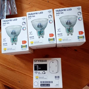 Ikea trådfria ledlampor med dosa  - Bilderna visar IKEA TRÅDFRI LED-lampor (GU10, 345 lm, 4.6W) och en STYRBAR fjärrkontroll för smart belysning. Perfekt för dig som vill styra belysningen trådlöst och skapa rätt stämning hemma. Kompatibelt med IKEA Home smart-systemet. Snygg och enkel lösning för ett smartare hem.
