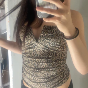 Leopardmönstrad tubtopp Stradivarius - Säljer en snygg leopardmönstrad tubtopp från Stradivarius. Toppen är figurnära med cool v-ringning framtill och har en croppad passform. Perfekt för dig som vill sticka ut med ett djurmönster! Materialet är stretchigt och bekvämt. 