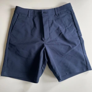 Mörkblå Calvin Klein shorts - Snygga mörkblå shorts med klassisk passform och raka ben. Perfekt för sommaren eller golfen. Säljer för 200kr. Storlek w28