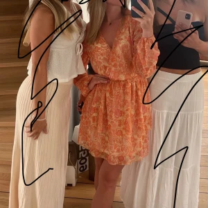 Orange klänning  - Så fin sommarklänning. Klänning är orange med lite rosa inslag och sedan med guld. Storleken är S men passar från xs-m. Klänningen är använd ungefär 3-4 gånger och i väldigt bra skick🌸 ej fast pris så buda på!