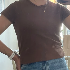 Brun t-shirt från Lindex - En basic brun t-shirt från Lindex i storlek M. Modellen är klassisk med rund halsringning och korta ärmar. Perfekt att matcha med jeans eller kjol för en enkel och snygg look.